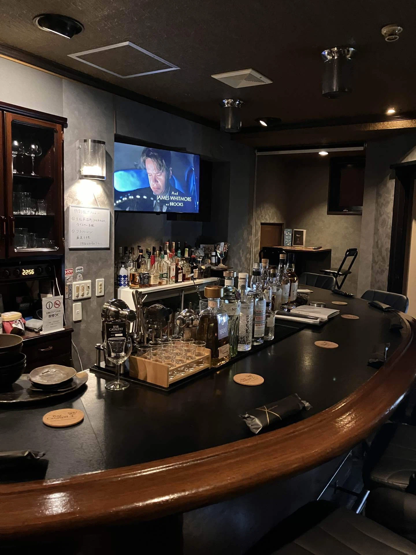 Bar CATALYSTの店内。木の縁取りのカウンターと並ぶボトル